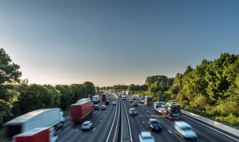 Sunset view heavy traffic moving at speed on UK motorway in England.